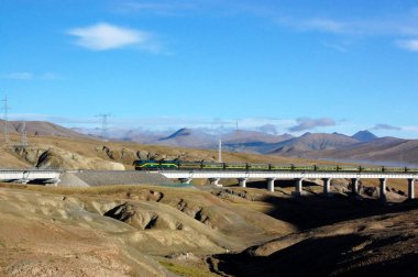 A passenger train travels on the Qinghai-Tibet Railway in the Kunlun Mountain area in northwest Chinas Qinghai province, 13 August 2011 clipart