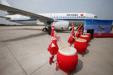 Chinese entertainers perform at a delivery ceremony in front of the 100th Airbus A320 plane assembled by Airbus (Tianjin) Final Assembly Line as it is delivered to Air China at the Airbus (Tianjin) Delivery Centre in Tianjin, China, 25 September 2012 clipart