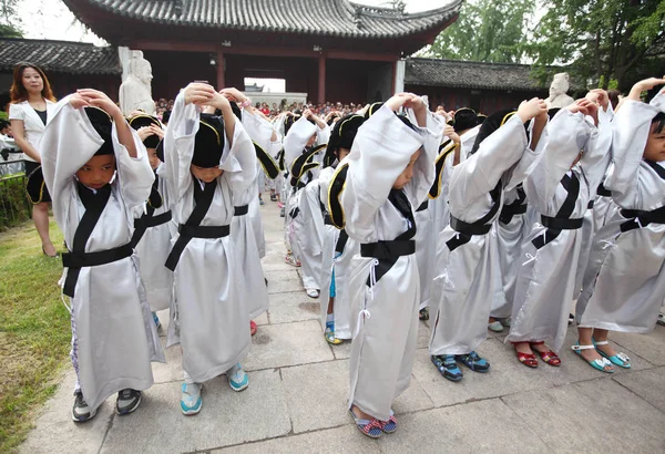 2012年9月1日 中国東部江蘇省南京市の孔子寺で行われた初めての書き込み式で 中国の伝統的な衣装を着た新入学した小学生がお辞儀をしました — ストック写真