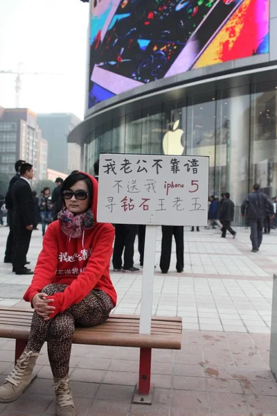 Μια Νεαρή Κινεζική Γυναίκα Κάθεται Δίπλα Ένα Πλακάτ Πινακίδες Ανάγνωση — Φωτογραφία Αρχείου