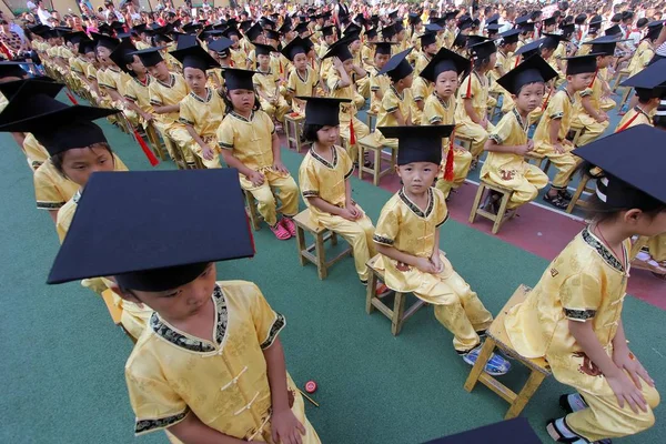 伝統的な衣装を身にまとった若い中国人学生は ジンジャン市の Gaoxia 小学校での孔子誕生の2563Rd 周年を記念して 最初の筆記式に参加しました Provinc — ストック写真