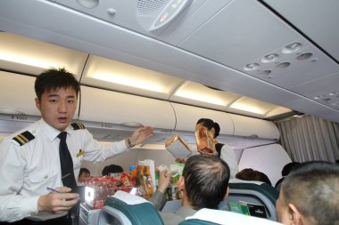 --FILE--Cabin crew members are pictured as they sell products during a flight from Harbin to Shanghai, China, 2 April 2011. clipart