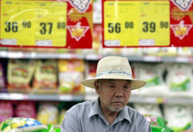A Chinese customer walks under price tags at a supermarket in Huaibei city, east Chinas Anhui province, 9 May 2012 clipart