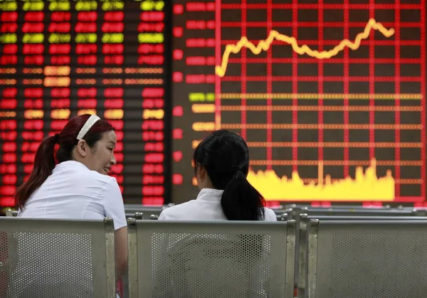 2012 日東中国安徽省淮北の株式仲買の家で 赤の価格上昇 と価格下落のため緑の株式の価格で見る中国人投資家 — ストック写真