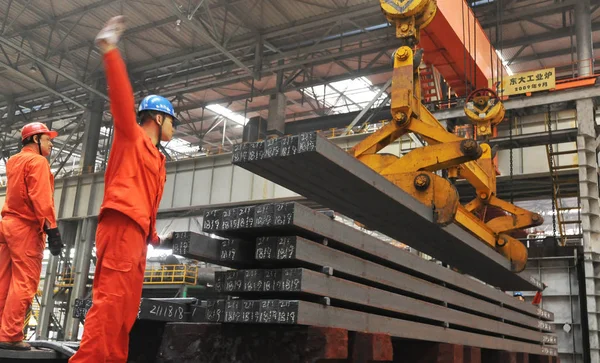 ファイル 中国の労働者は 2012年6月19日 中国北東部の大連市の東北特殊鋼グループの鉄鋼工場で鉄鋼製品を持ち上げるようクレーンを指示する — ストック写真
