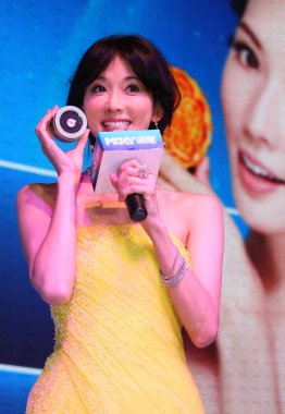 Taiwanese model and actress Lin Chi-ling (yellow) speaks during a promotional activity in Chengdu city, southwest Chinas Chengdu province, 31 August 2012. clipart