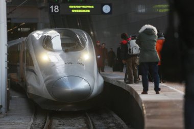 Journalists take photos of a CRH (China Railway High-speed) bullet train to travel on the Beijing-Guangzhou High-speed Railway at the Beijing West Railway Station in Beijing, China, 22 December 2012 clipart