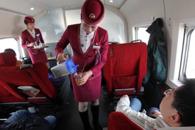 Chinese attendants offer tea to journalists aboard a CRH (China Railway High-speed) bullet train running on the Beijing-Guangzhou High-speed Railway in China, 22 December 2012 clipart