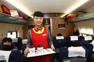A crew member of CRH (China Railway High-speed) bullet train services coffee to passengers during going on the Beijing-Guangzhou High-speed Railway, 26 December 2012 clipart