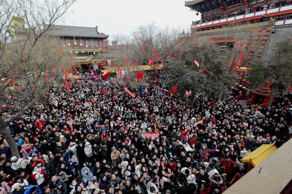 観光客の群衆として中国の旧正月または Cen 開封市の春祭りの 日に祝福を受けることとしても知られている Caishen 富神の服を着て中国の芸能人から赤のポケット マネーを取得するミレニアム都市公園 — ストック写真