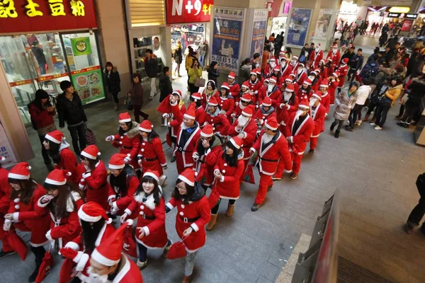 2012年12月24日 中国湖北省武漢市のクリスマスを祝うショッピングモールで サンタクロースの衣装を着た若い中国人大学生がパレードを行いました — ストック写真