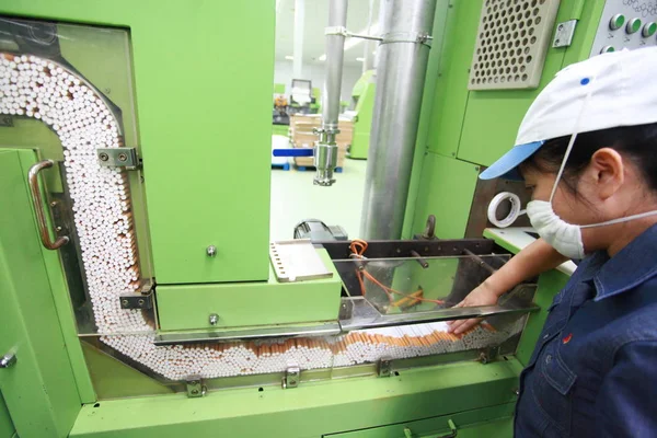 2012年8月26日 一名中国工人在海南省海口市海南红塔卷烟有限公司的厂房监督红塔山卷烟的生产 — 图库照片