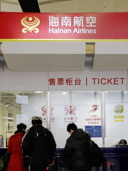 訪問者は 中国の空港で海南航空のチケットカウンターでチケットを購入します 2012年2月27日 — ストック写真