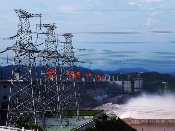 長江からの水は 中国中部湖北省のYichang市のパイロンと高圧送電線に隣接する三峡ダムから噴出します 2012年7月5日 — ストック写真