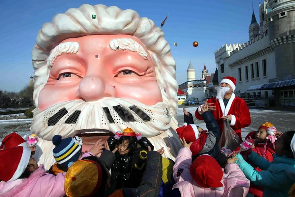 2012年12月23日 中国北京世界公园 一名身着圣诞老人服装的中国青年向孩子们分发礼物 以庆祝圣诞节 — 图库照片