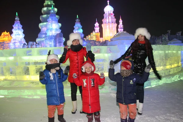 2012年12月27日 在中国东北黑龙江省哈尔滨市举行的第14届冰雪世界冰雕前 游客们在冰雕前合影留念 — 图库照片