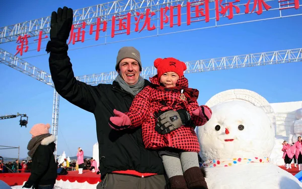 2011年1月8日 在中国东北辽宁省沈阳市举行的第14届沈阳国际冰雪节上 游客们与一名雪人合影 — 图库照片