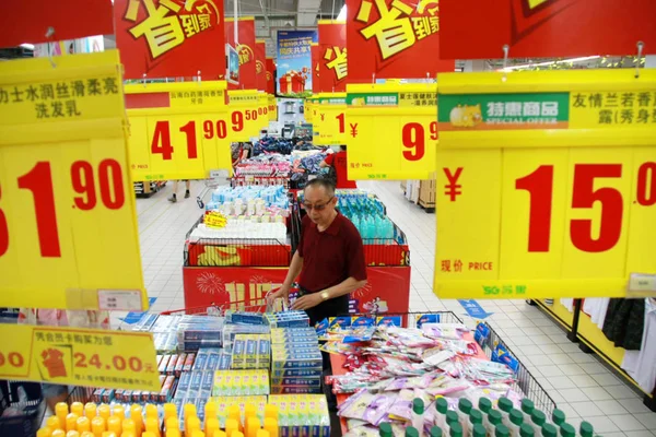 中国の顧客は 2011年7月9日 中国東部江蘇省南通市のスーパーマーケットで価格タグの下で買い物をしています — ストック写真
