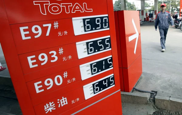 中国のスタッフは 武漢市中央中国湖北省のガソリンスタンド 10月26日 2010で燃料価格を示すボードを歩き過ぎた — ストック写真