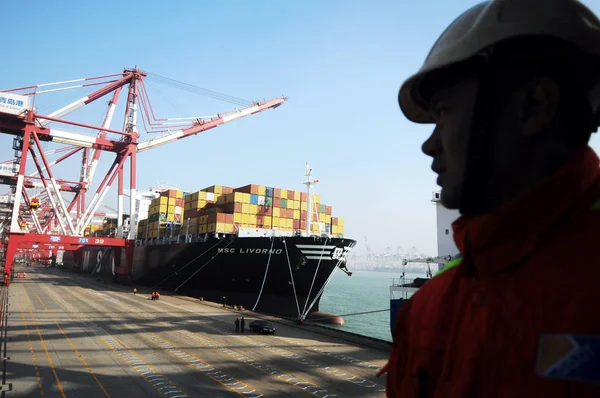 A Chinese worker looks at the worlds largest container ship MSC Livorno at the Port of Qingdao in Qingdao city, east Chinas Shandong province, 20 December 2010 — Stock Image Chinese Worker Looks Worlds Largest Container Ship Msc Livorno Port Royalty Free Stock Images