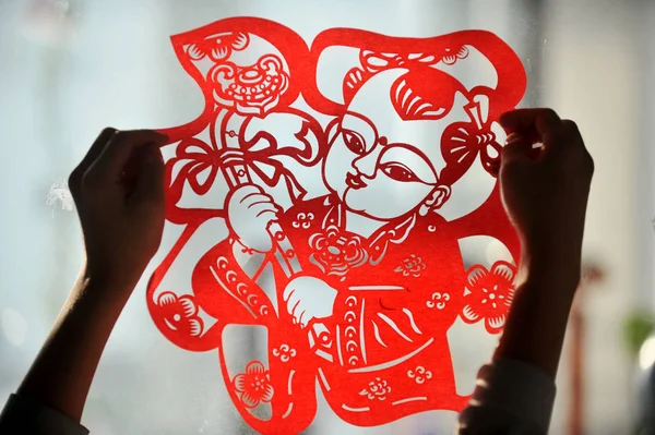 地元の中国人の居住者が 中国の旧正月として知られるこの春祭りの準備のために 窓に紙カットの作品を貼り付け 中国遼寧省北東部の瀋陽市で 1月24日2011 — ストック写真