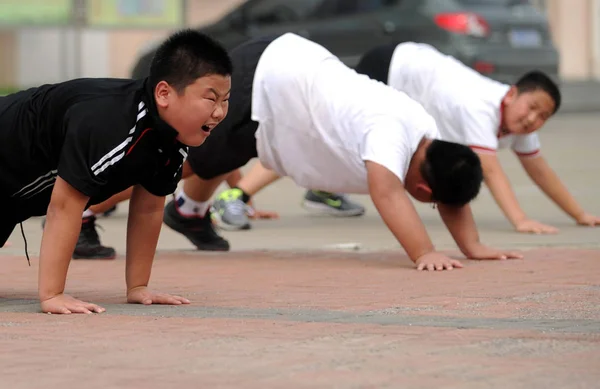 2011年8月13日 在中国天津的一个军事训练营 肥胖男孩在减肥练习中做俯卧撑 — 图库照片
