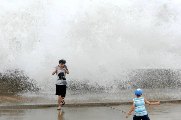2011년 산둥성 칭다오시의 해안을 강타한 무이파로 파도에서 도망치는 관광객들 — 스톡 사진