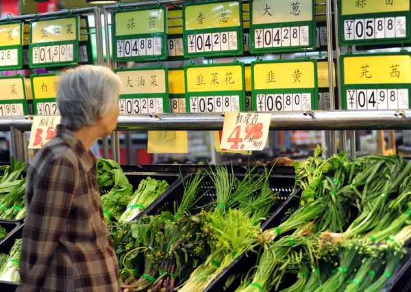 顧客は 中国南部海南省の青海市のスーパーマーケットで野菜の価格を見ます 2011年10月9日 — ストック写真