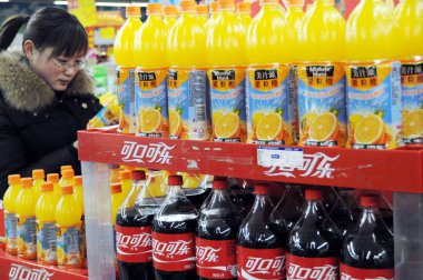 Bottles of Minute Maid Pulpy juice and cola of Coca-Cola are for sale on the shelf at a supermarket in Binzhou city, east Chinas Shandong province, 12 January 2011 clipart