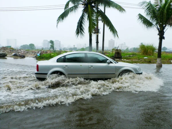 2011年9月29日 在中国海南省海口市 一辆小汽车在暴雨中行驶在被洪水淹没的街道上 — 图库照片