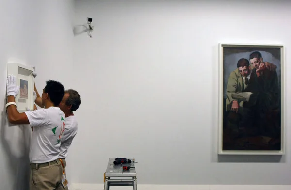 2011年10月13日 两名工人在中国上海中国馆筹备2011年中国毕加索画展时 挂出西班牙艺术家巴勃罗 毕加索的一幅画 — 图库照片