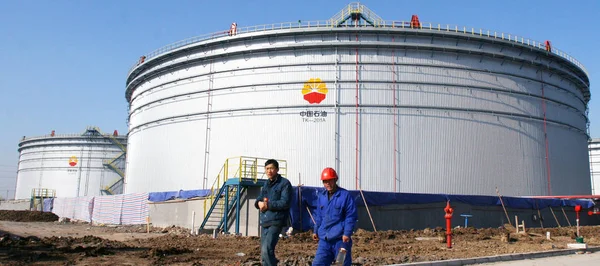 労働者は 2010年12月23日 中国北部天津省ビンハイにあるCnpc 中国国家石油公社 の子会社 ペトロチャイナの原油貯蔵工場を通り過ぎる — ストック写真