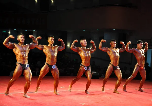 2011년 28일 후양시에서 보디빌딩 피트니스 엘리트 인비테이셔널 대회에서 참가자들이 근육을 — 스톡 사진