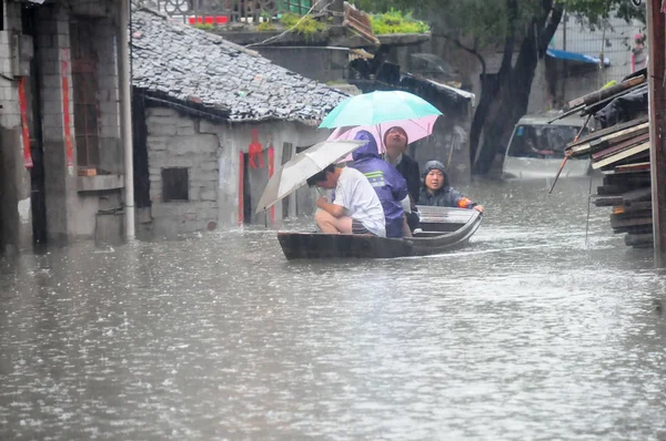 人们在船上被洪水淹没的街道 — 图库照片