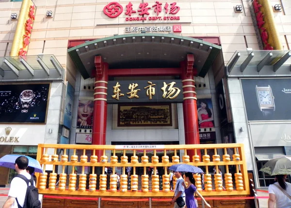 2011年9月4日 在中国北京王府井步行街 游客们走过一个巨大的金色算盘 — 图库照片