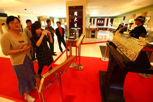 訪問者は 南京市の中心商店街 東中国江蘇省の宝石祭りの間に巨大な金のバーの写真を撮ります 月2011 — ストック写真