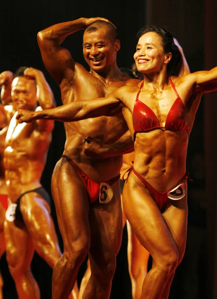 出場者は 2011年8月28日 中国東部安寧省福陽市で開催された全国ボディービルとフィットネスエリート招待大会で筋肉を見せる — ストック写真