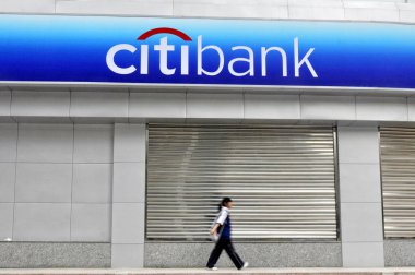 A student walks past a branch of Citibank in Changsha city, central Chinas Hunan province, 16 June 2011 clipart