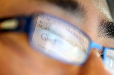 Gmail, Googles email service, is reflected in the glasses of a Chinese netizen, in an office in Shanghai, China, 21 March 2011 clipart