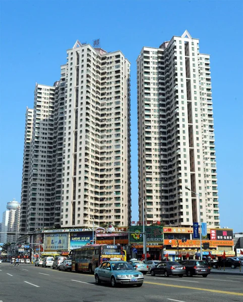 2009年10月7日 中国南部広東省東莞市の高層住宅マンションを車やバスが通り過ぎる — ストック写真