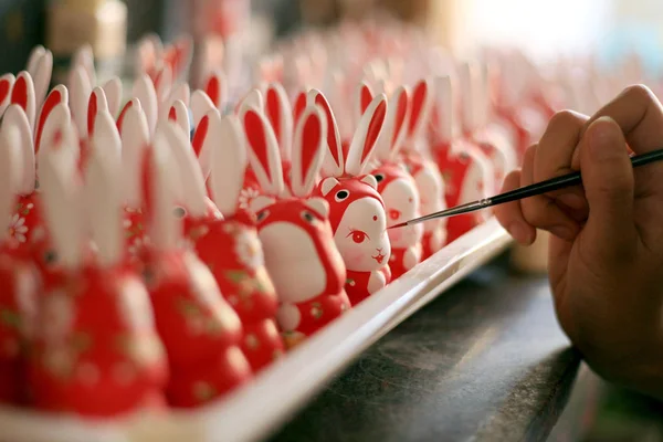 2011年8月31日 中国東部山東省済南市のワークショップで 月祭りとも呼ばれる中秋祭りのお土産として販売される粘土ウサギを塗装する作業員が描く — ストック写真