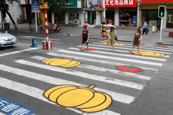 地元住民は 中国四川省南西部の三陽市の通りでカボチャとトマトの絵画で横断歩道を渡る 2011年8月24日 — ストック写真