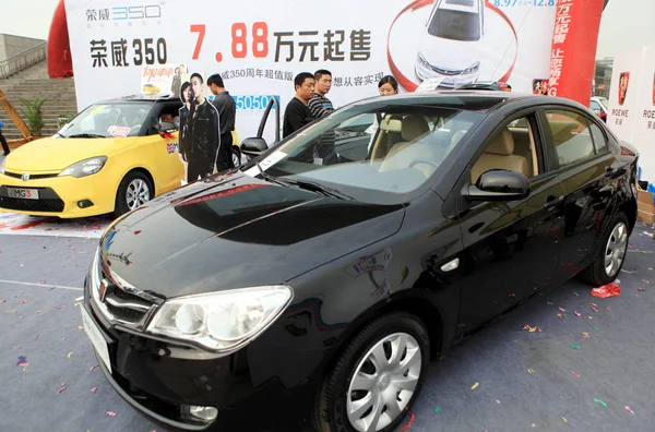 訪問者は 2011年4月9日 中国東部江西省の浙江市で行われた自動車ショーで Roewe 350とサイックモーターのMg3を見ます — ストック写真