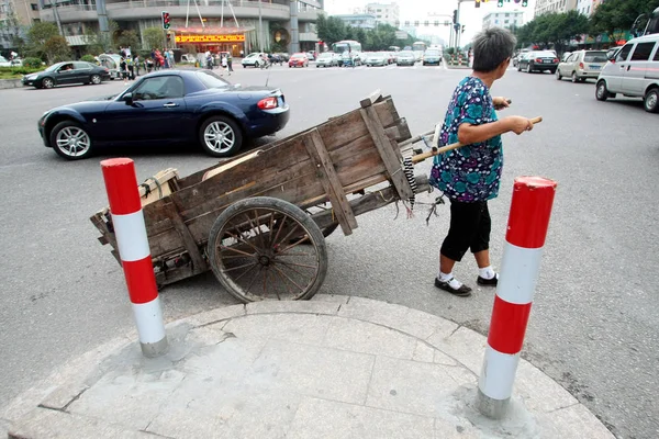 2011년 10월 11일 저장성 원저우시의 도로에서 초라한 손수레를 여성이 스포츠카를 — 스톡 사진