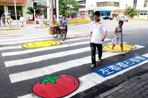 地元住民は 中国四川省南西部の三陽市の通りでカボチャとトマトの絵画で横断歩道を渡る 2011年8月24日 — ストック写真