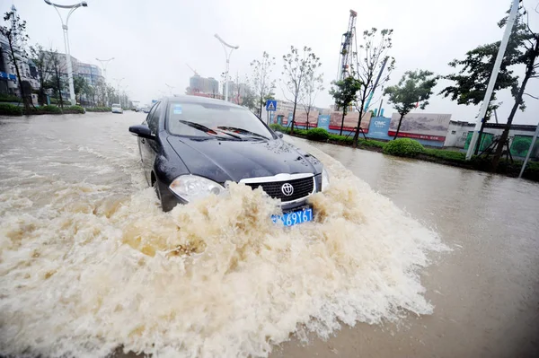 2011年6月25日 在中国东部江苏省扬州市 一辆小汽车在暴雨中行驶在被洪水淹没的街道上 — 图库照片