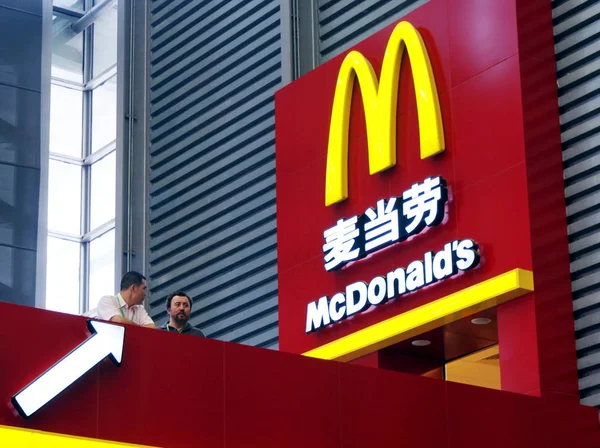 2009年6月23日 两名当地居民站在中国上海一家麦当劳餐厅前 — 图库照片