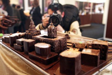 A photographer takes pictures of chocolate-made replicas of the constructions along the Bund during the chocolate show, Salon du Chocolat, in Shanghai, China, 21 January 2010 clipart
