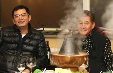 Hong Kong film director Wong Kar-wai (L) and Chinese comedy artist Zhao Benshan eat hot pot at a restaurant in Shenyang, northeast Chinas Liaoning province, January 6, 2010. clipart
