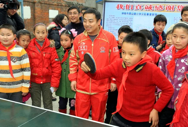 中国国民男子卓球部の劉 Guoliang センター ヘッドコーチは 世界トップテーブルテニス選手が地震を訪れたときに卓球をしている学生を見守ります Beichuan ミアンヤン市 南西中国四川省 Provinc — ストック写真
